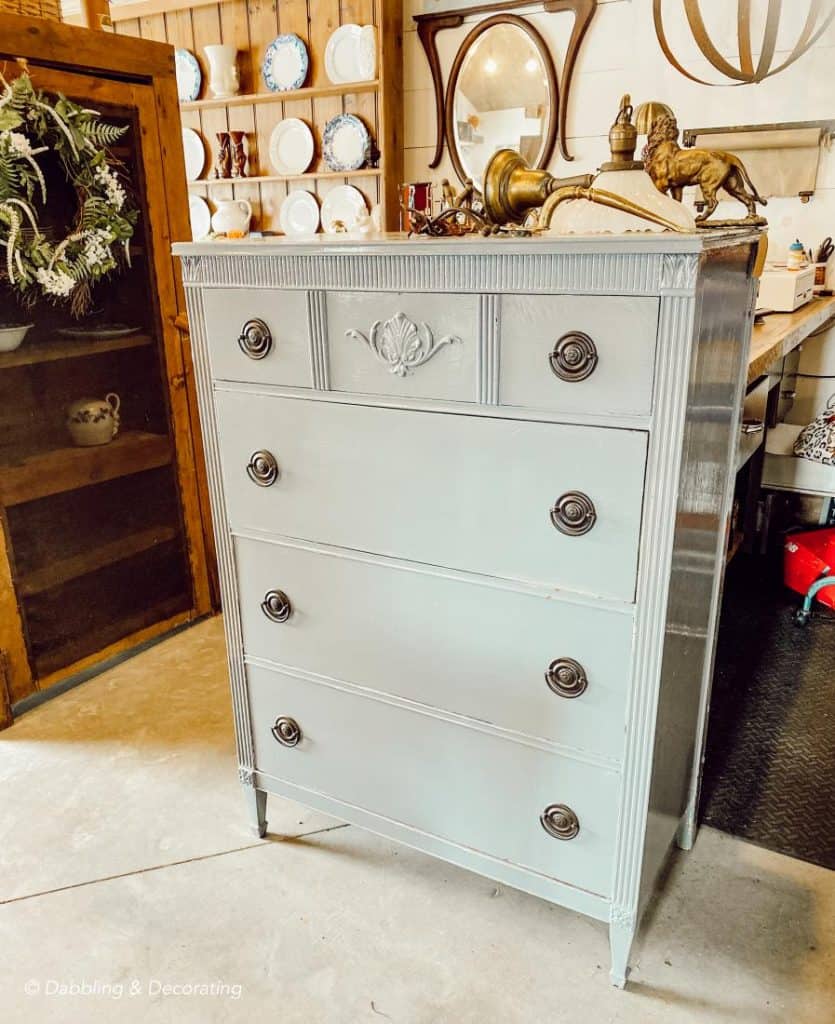 A thrifty gray painted dresser adds decor to a room. vintage dresser decorating ideas.