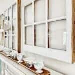 Vintage windows and teacups on a mantel