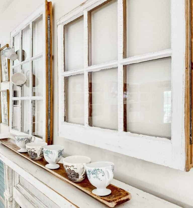 Vintage windows and teacups on a mantel