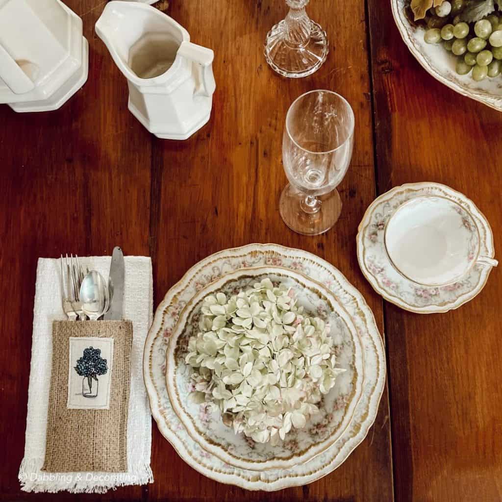 A vintage table setting with plates and silverware on a wooden table.