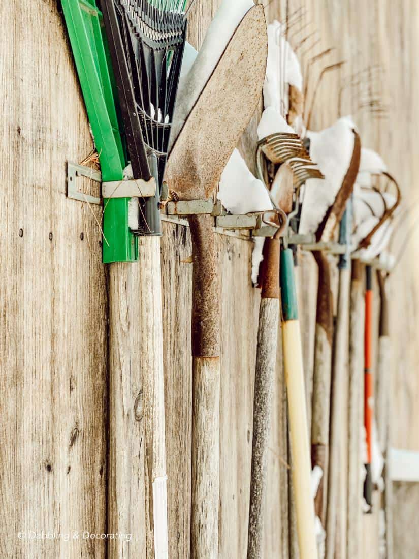 Vintage tools hanging on the side of the home.