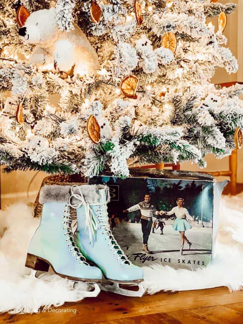 Christmas tree with vintage blue skates and box under it.