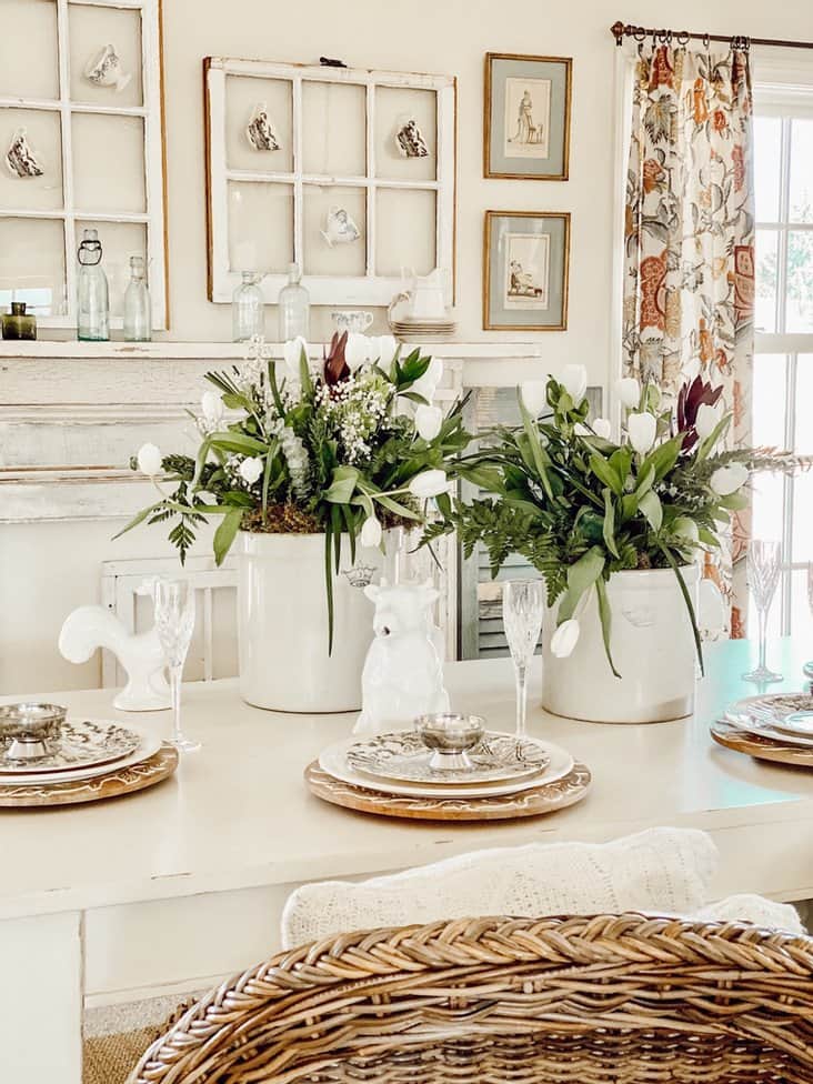 Antique Crocks with spring floral decorations on dining room table.