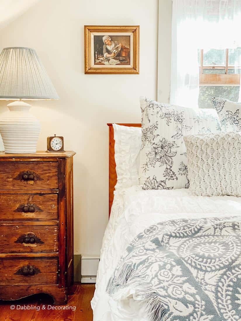 Bed in attic bedroom with vintage details and cozy bedding.