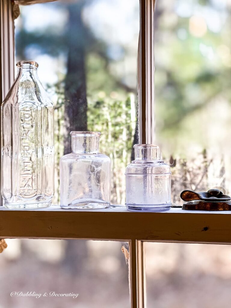 Window sill decor ideas with small vintage bottles.