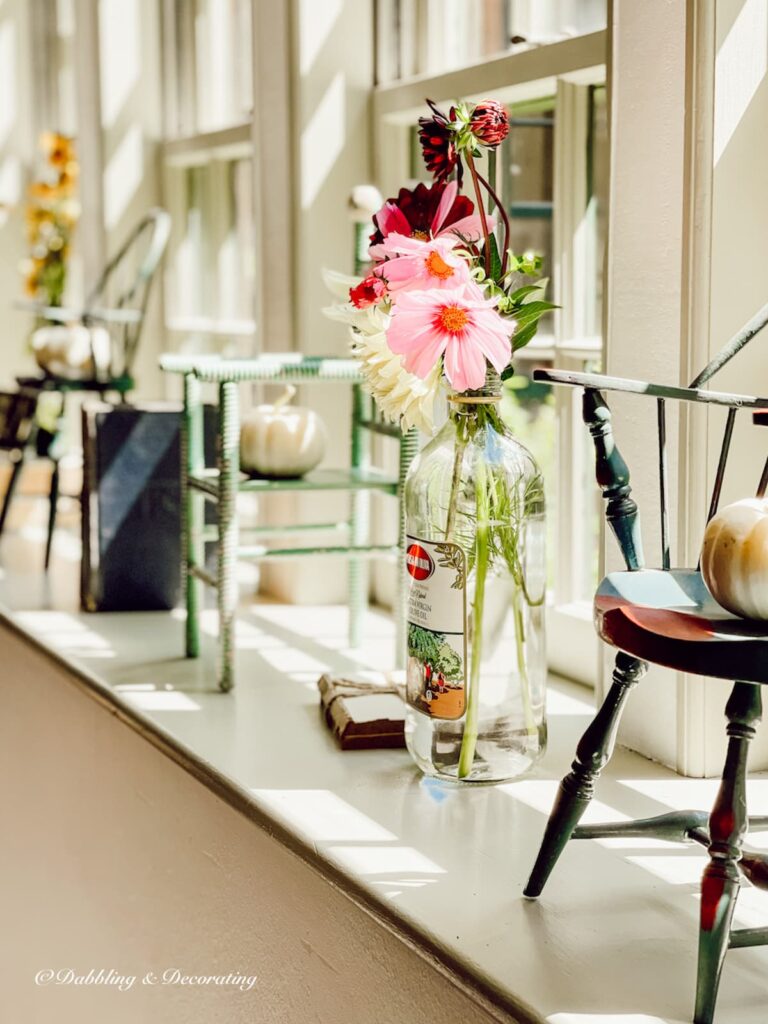 Window sill decor ideas with collected doll chairs, vintage books, flowers decorated for fall.