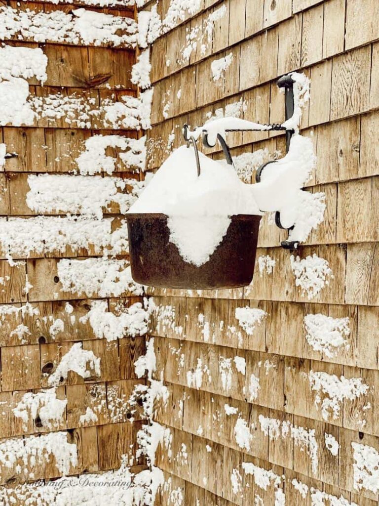 Vintage Iron Pot hanging on cedar shakes home on snow days.