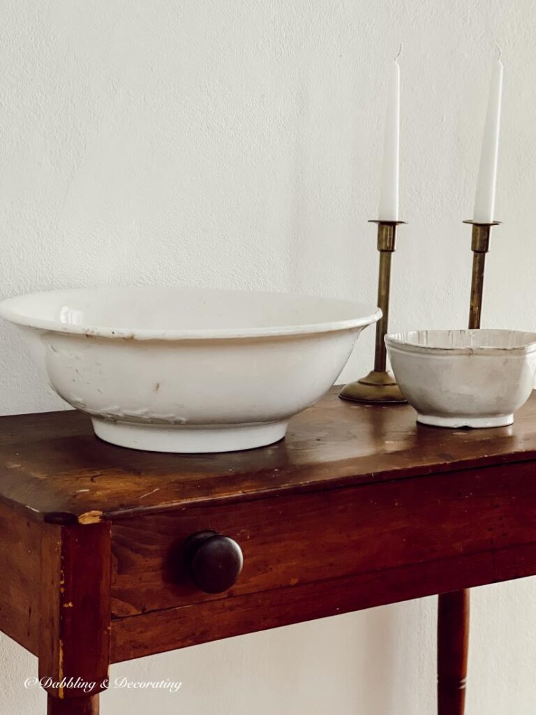 Vintage Ironstone bowl and candlesticks on antique table.