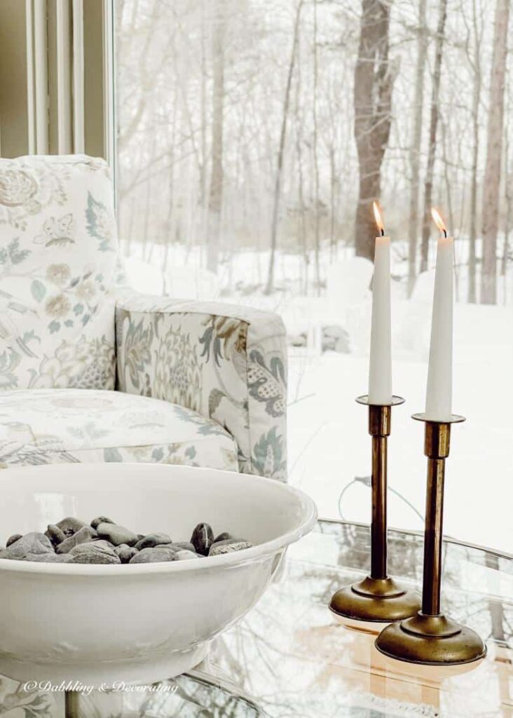 Ironstone bowl with beach rocks and candlesticks in sunroom