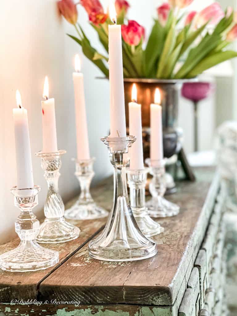 Glass candlesticks with candles on rustic surface.