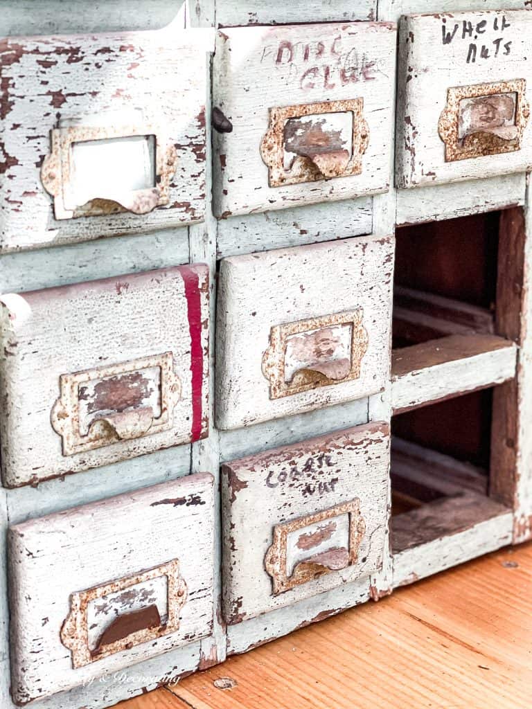 Chippy apothecary cabinet with missing drawer.