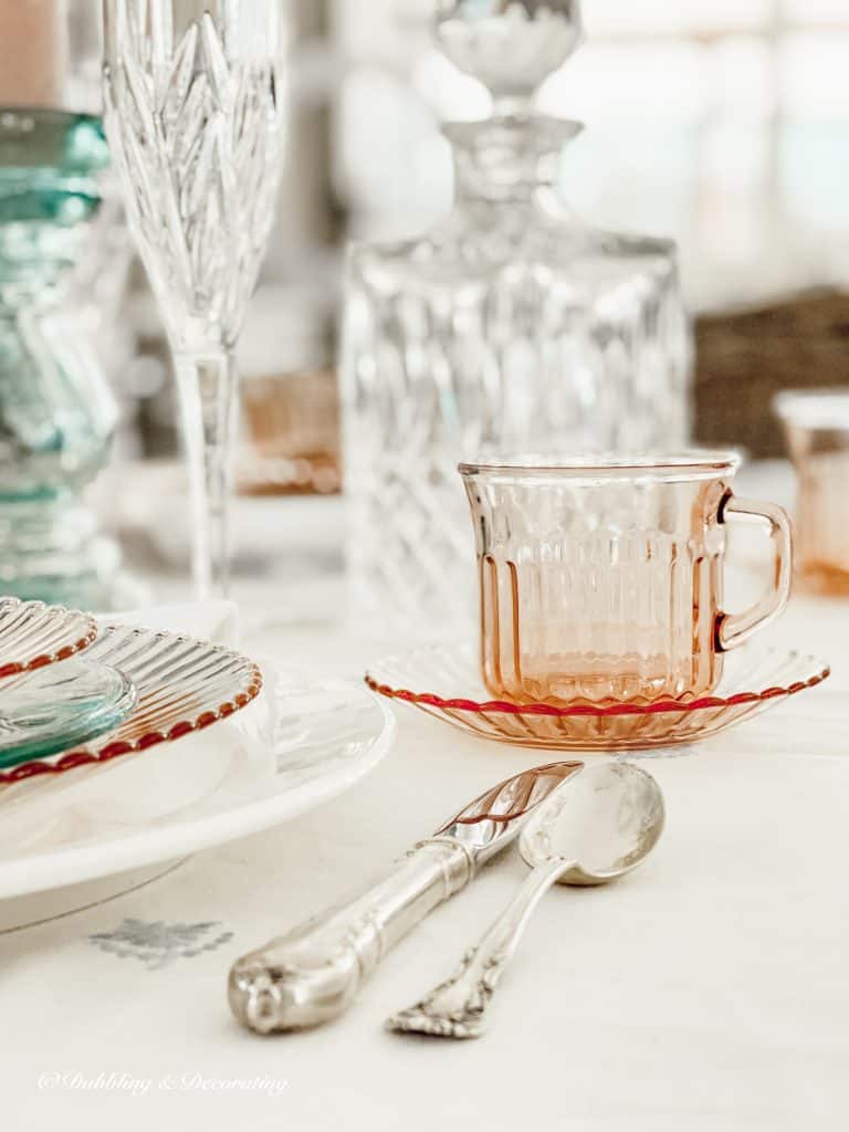 Depression Glass Cherry Blossom cup and saucer place setting.