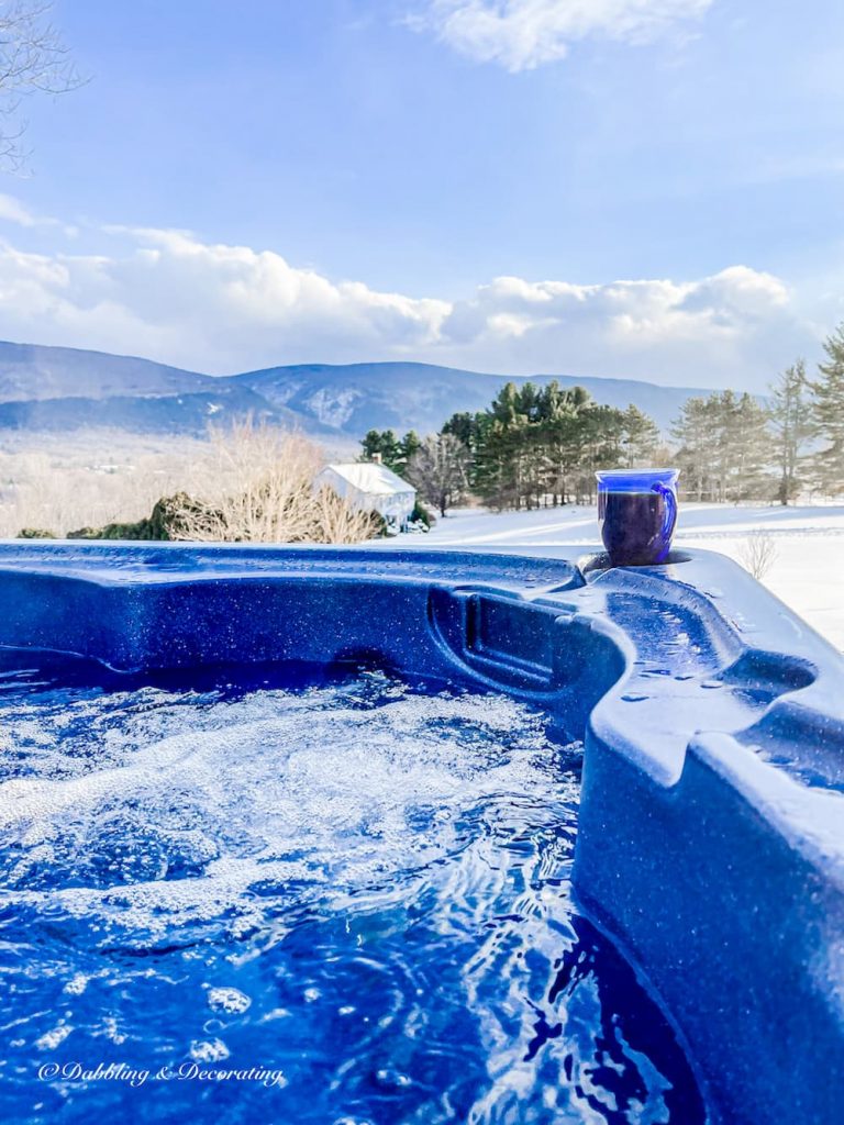 Hot Tub Mountain Views with snowy mountains and a blue glass vintage coffee mug resting on the side.