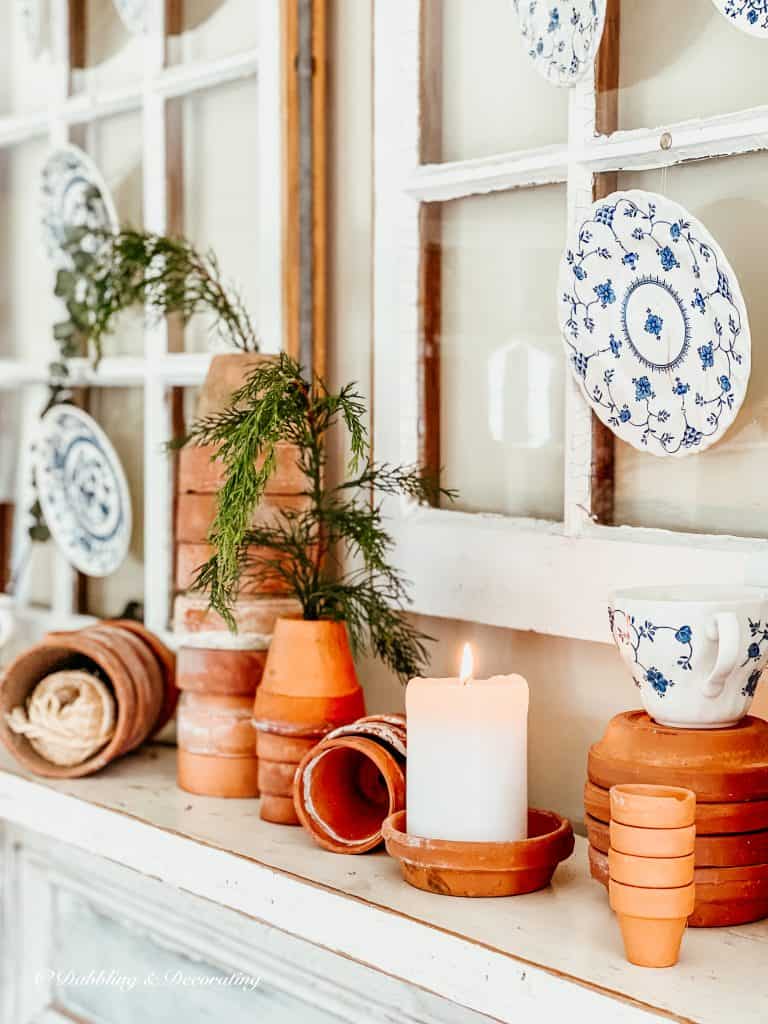 Terracotta pots scattered on a mantel.