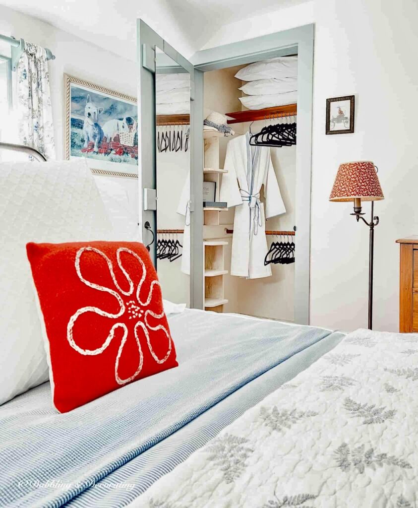 Coastal styled vintage bedroom with newly styled closet with velvet clothes hangers and bathrobe.