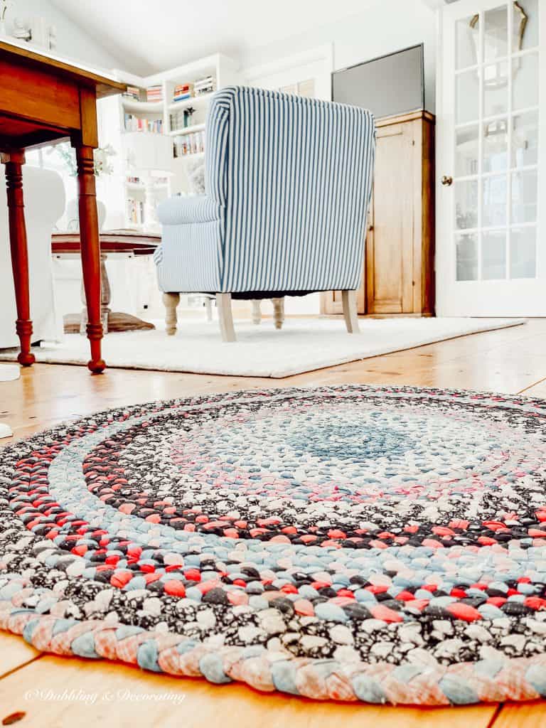 A braided rug on a wood floor