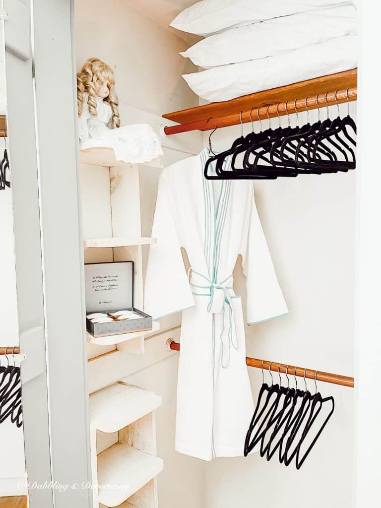 Black Velvet Clothes Hangers in guest bedroom closet with bathrobe.