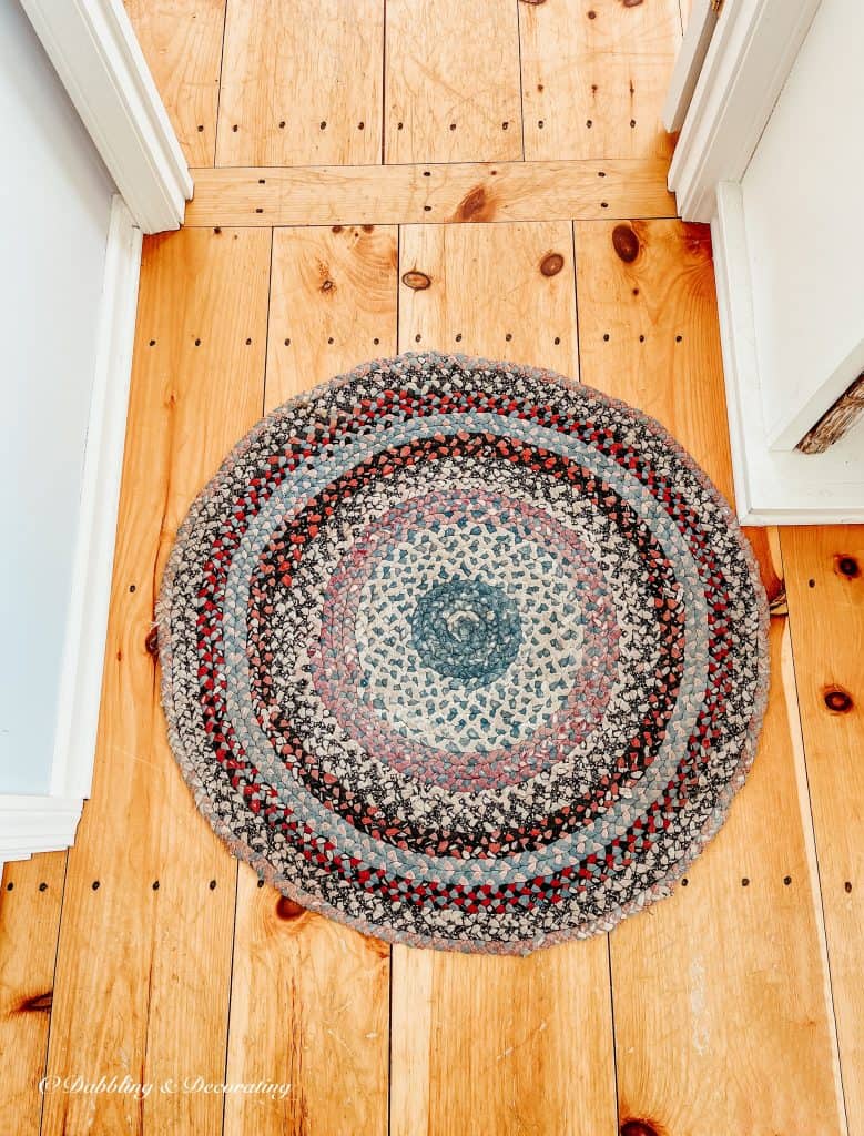 A braided rug on a wood floor