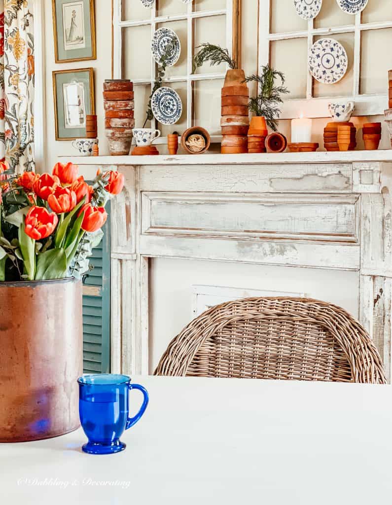 Vintage Mantel with stacked terracotta pots and a bucket of tulips.