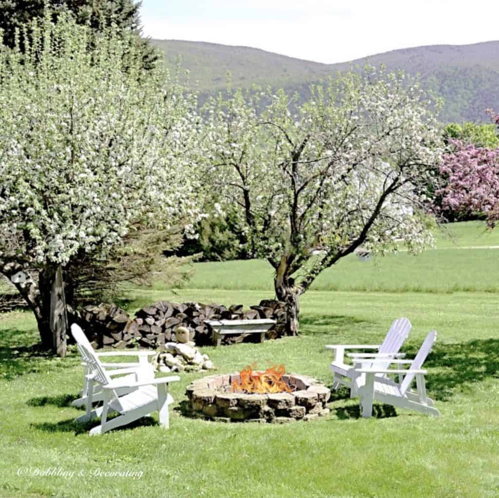 Spring Backyard Vermont view with fire pit and Adirondack chairs.