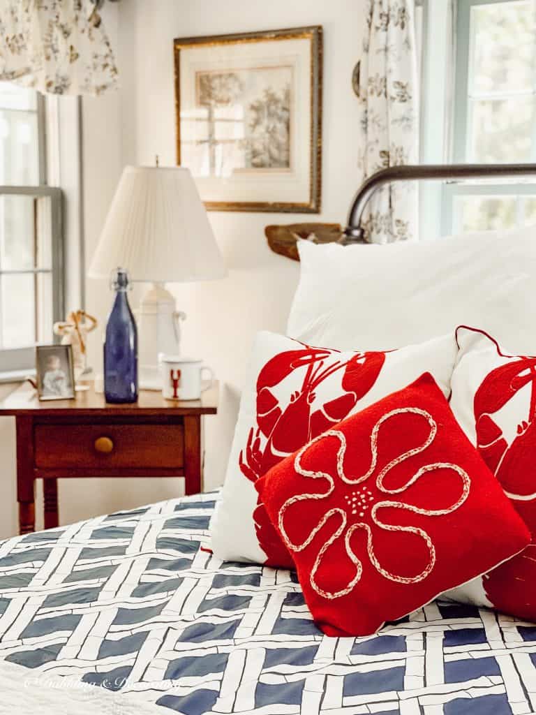 A thrifty bed with red and white pillows on it.