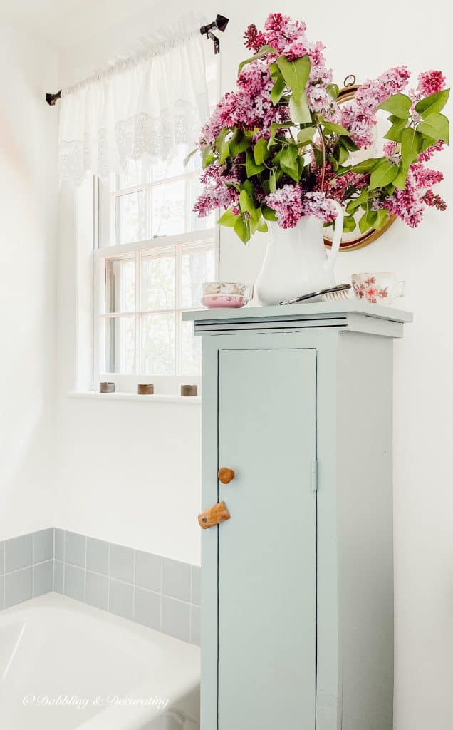 Lilacs on a blue cupboard in the bathroom.