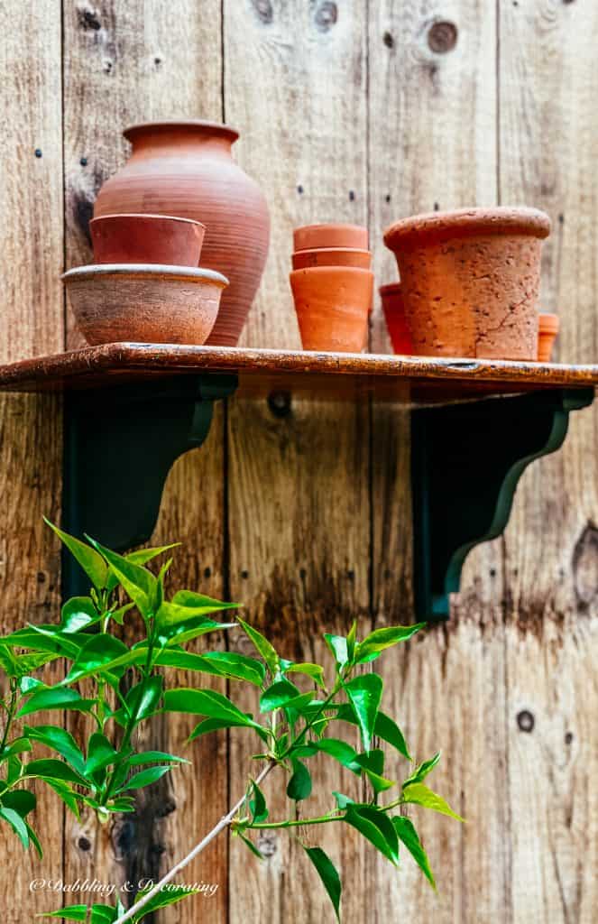 Outdoor DIY Planter Shelf with terracotta pots.