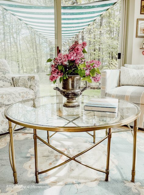 Sunroom with Four Seasons Furniture and glass coffee table with Lilacs