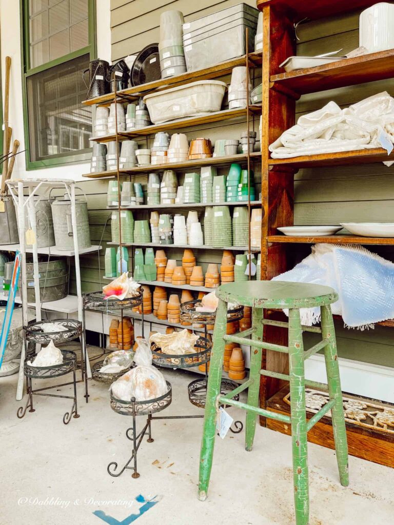 outdoor terracotta pots and green stool and gardening tools vintage at outdoor market.