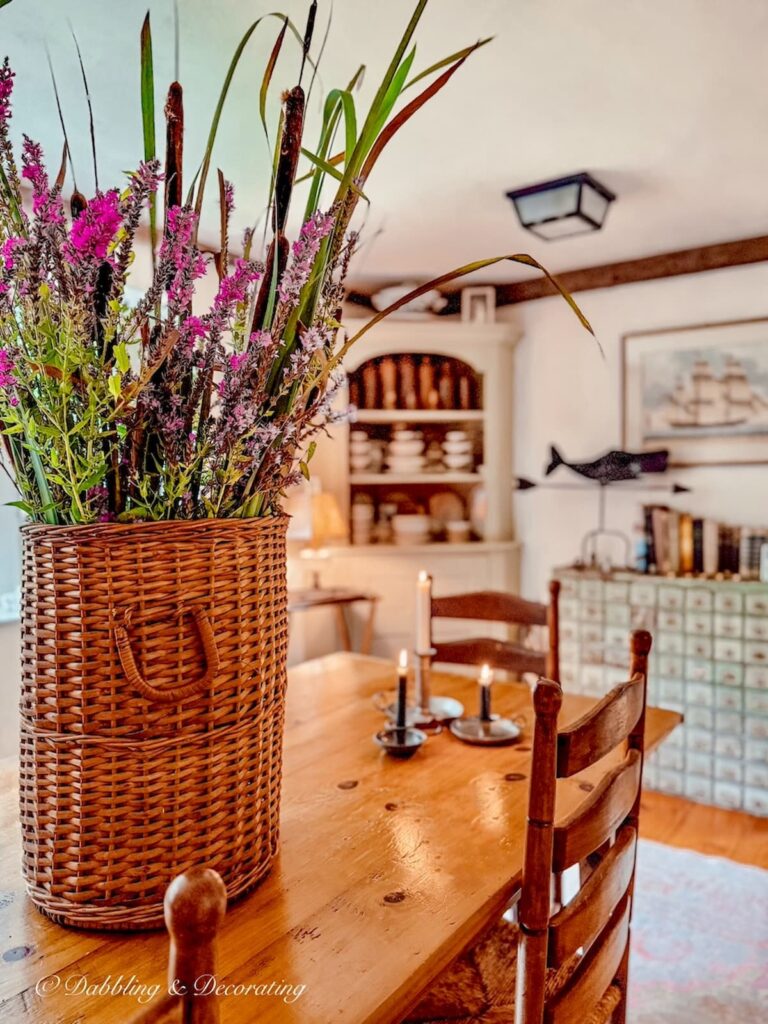 Cattail and Purple Wildflower Arrangement in a Vintage Basket on antique dining room table.