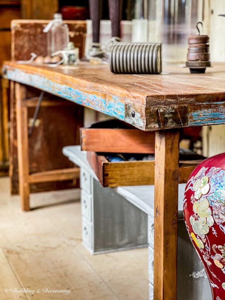 Vintage wallpaper table displayed in antique store with blue touches.