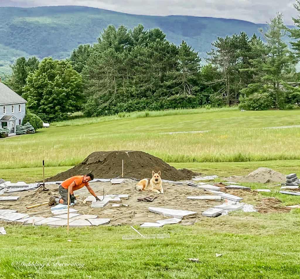 Man with dog installing corinthian granite patio