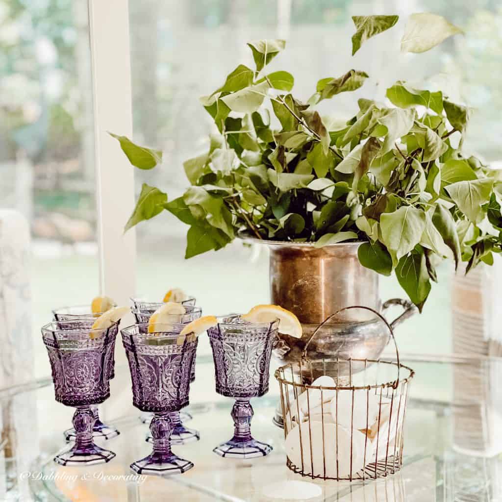 Antique amethyst glassware with lemon on coffee table.