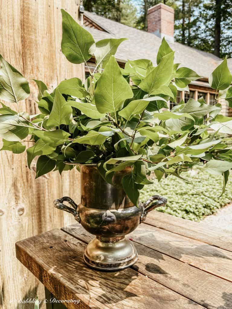 Champagne bucket filled with lilac branches.