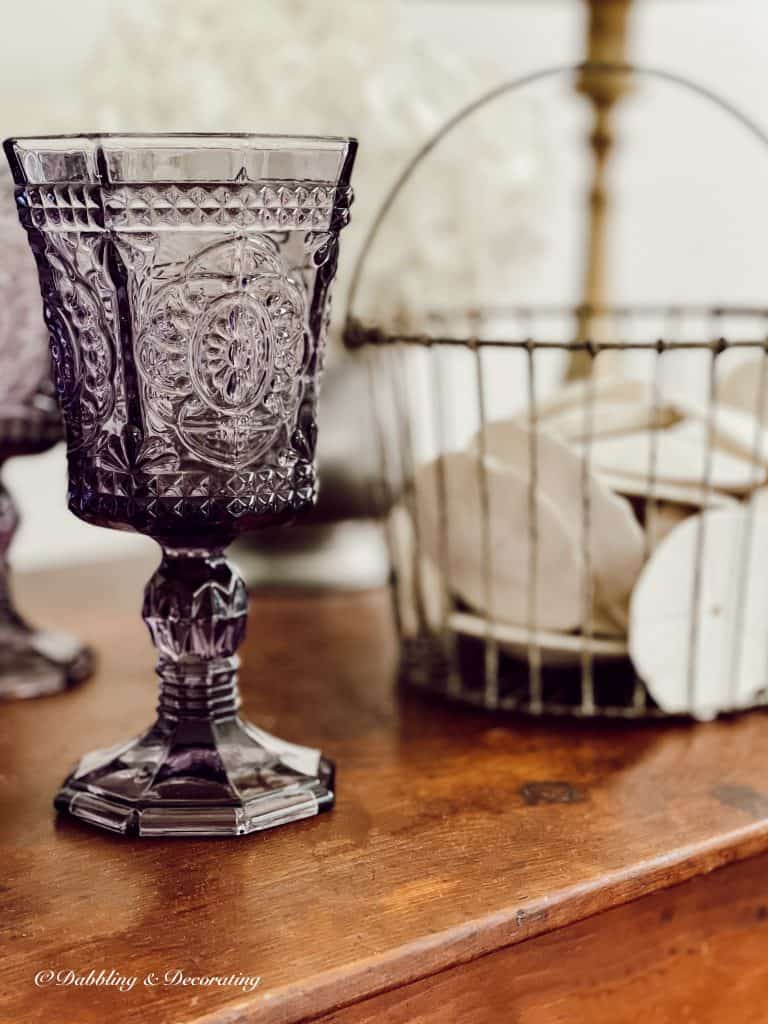 antique amethyst glass on dark wood table.