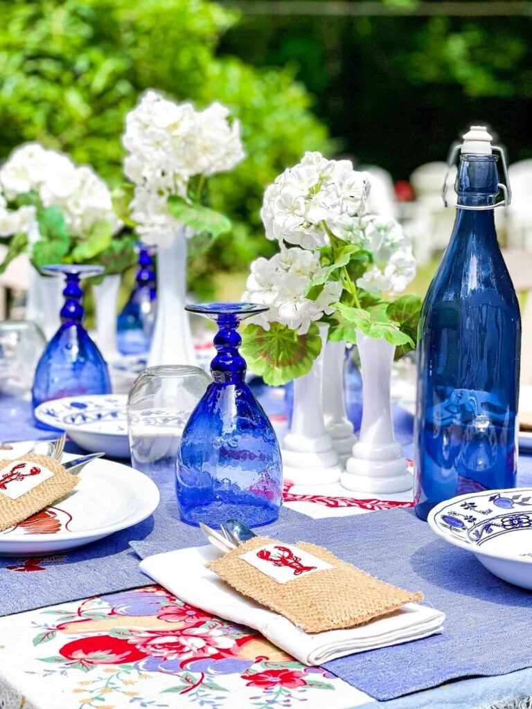 Patriotic outdoor summer tablescape with blue goblets, and lobster theme.