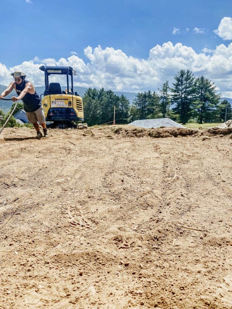 Man leveling dirt for a patio design.