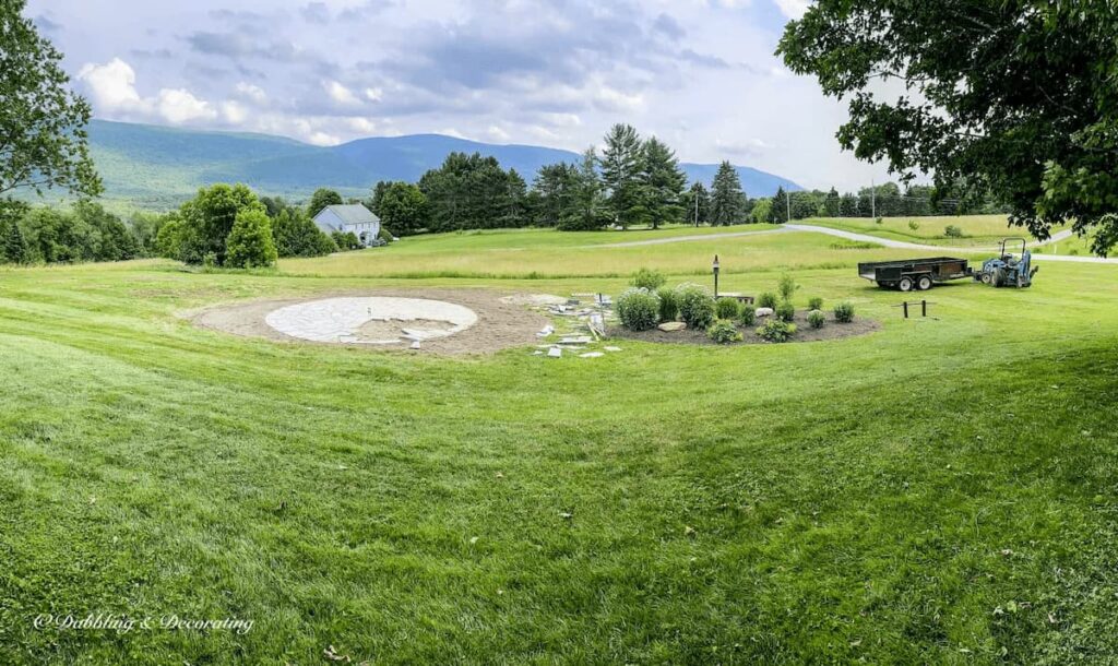Panoramic view of the backyard with circle fire pit patio nearly completed.
