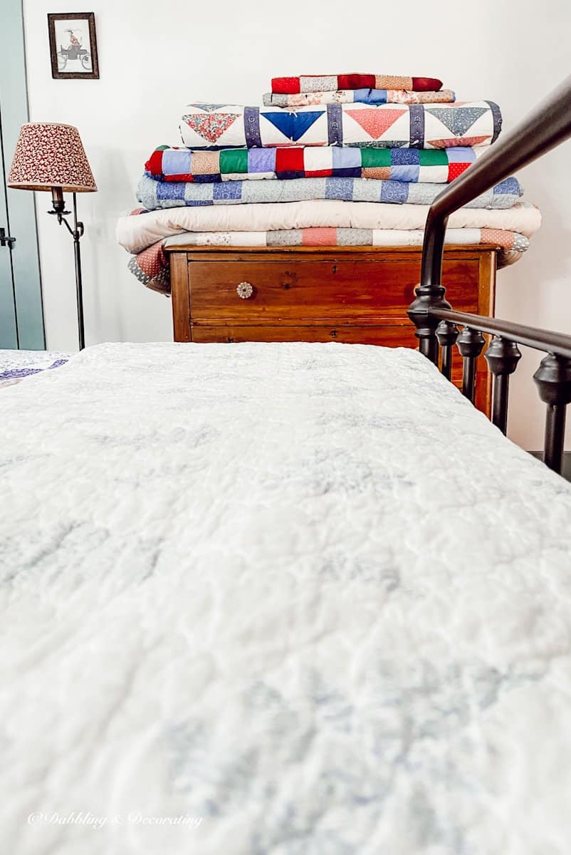 folded and displayed quilts in bedroom