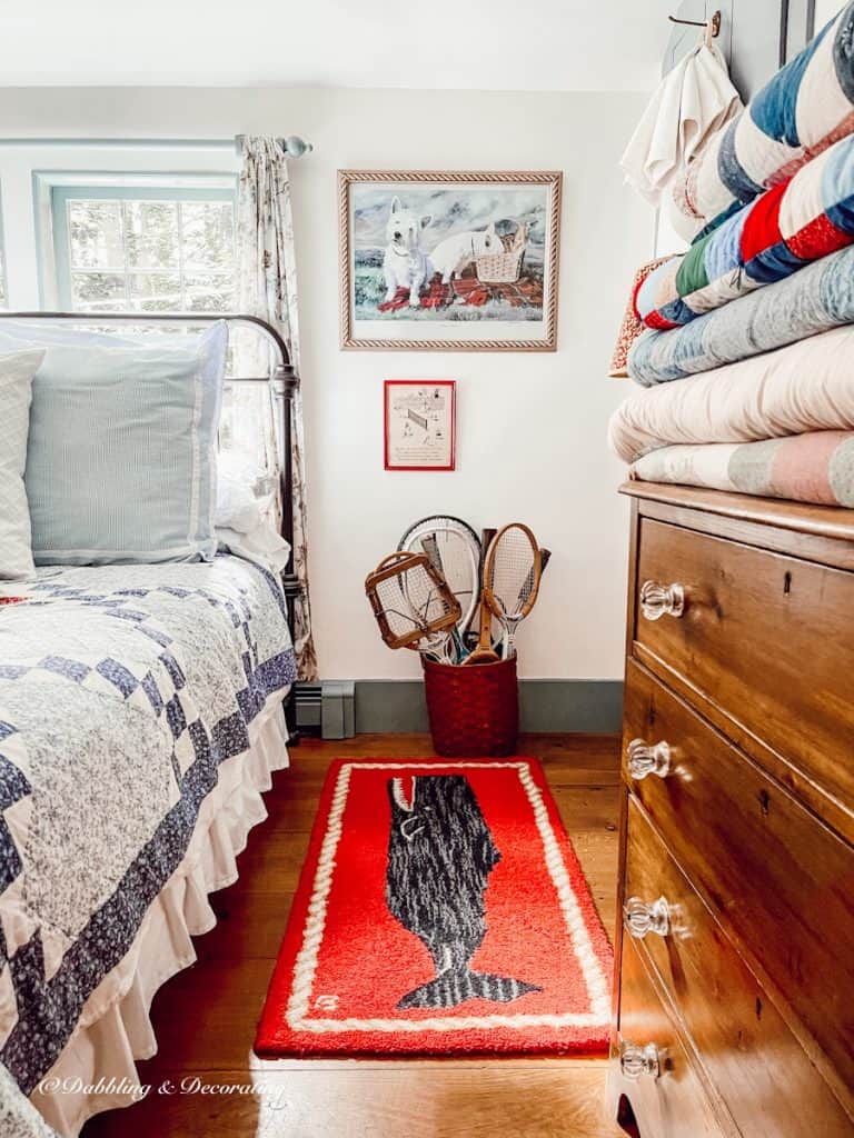 bedroom with quilts and basket of tennis racquets.