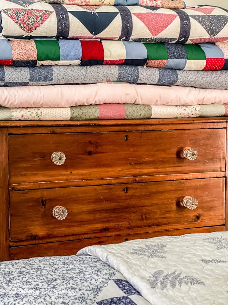 Vintage quilt collections on dresser.