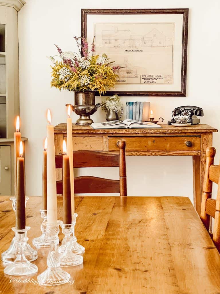 Wildflower arrangements in vintage vessels on antique desk.