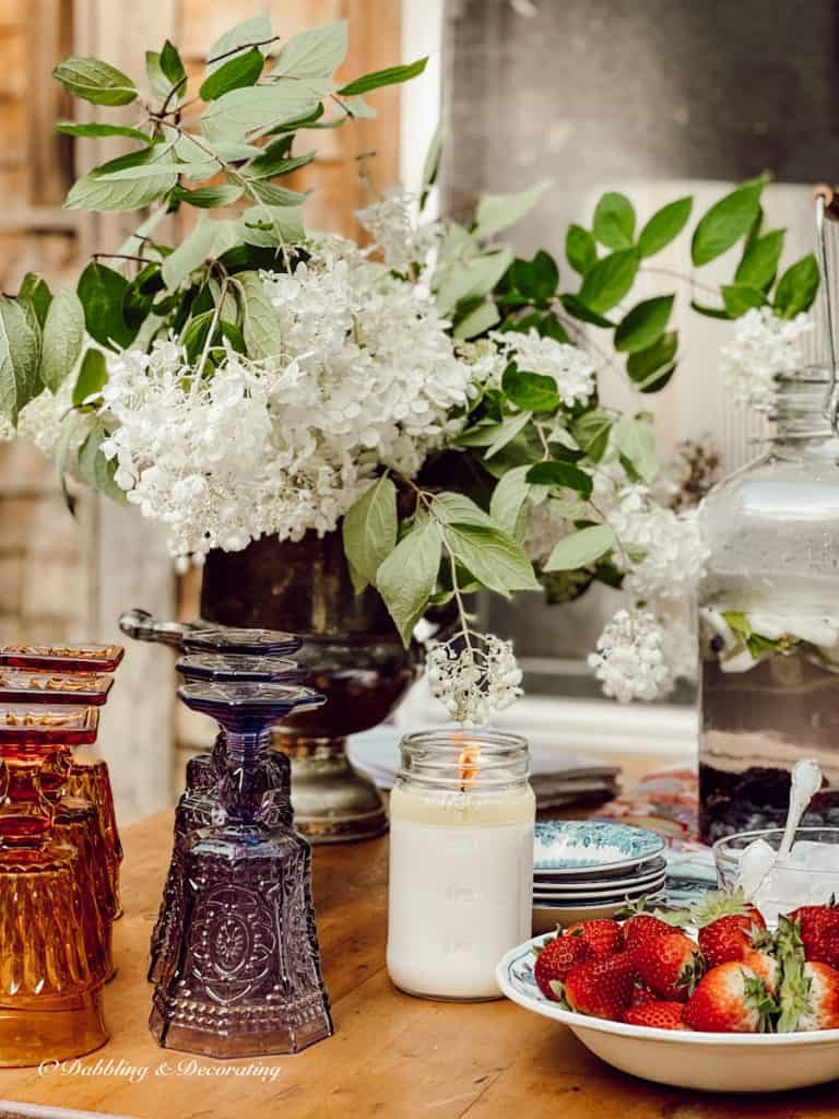 Beautiful glassware on an outdoor country table with strawberries.