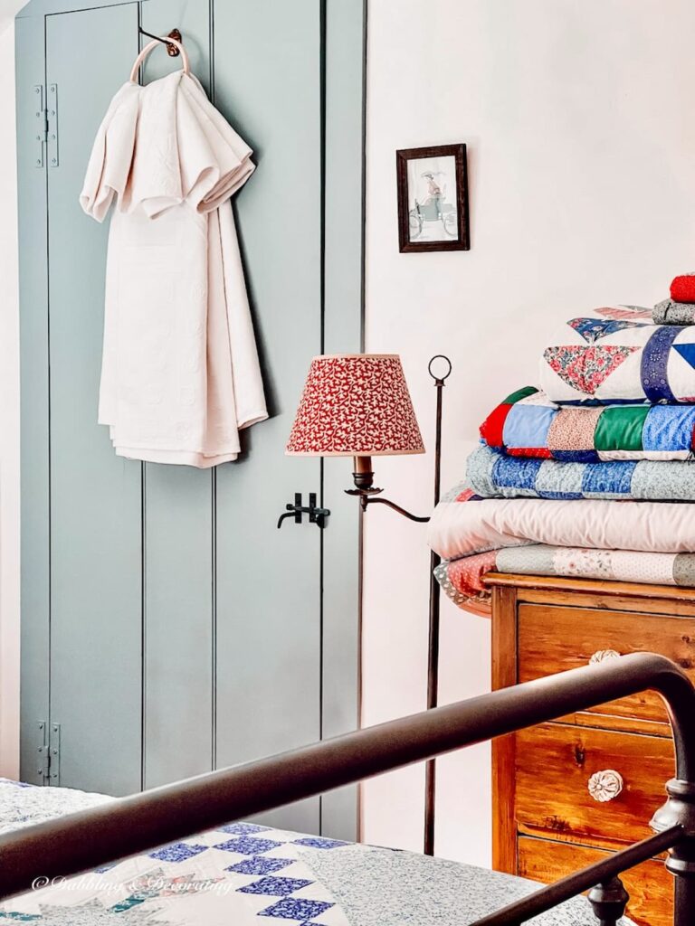 Heirloom white quilt displayed on bedroom door with embroidery hoop.