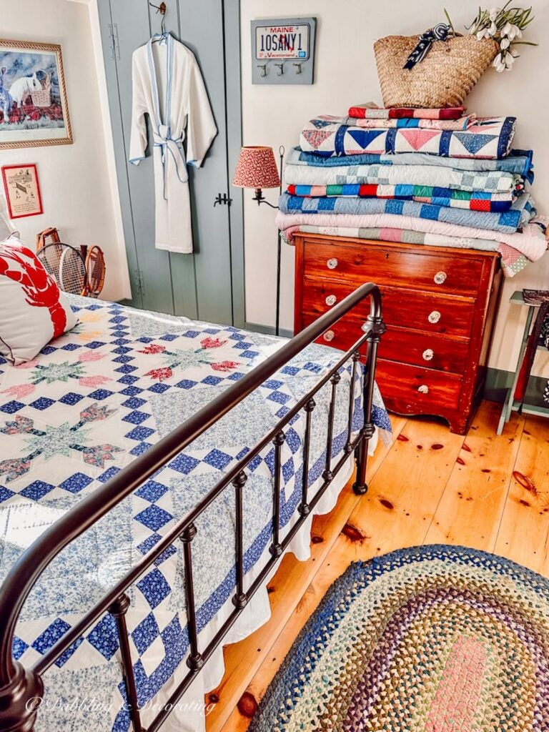 Quilts folded and displayed on bedroom dresser in vintage style small bedroom