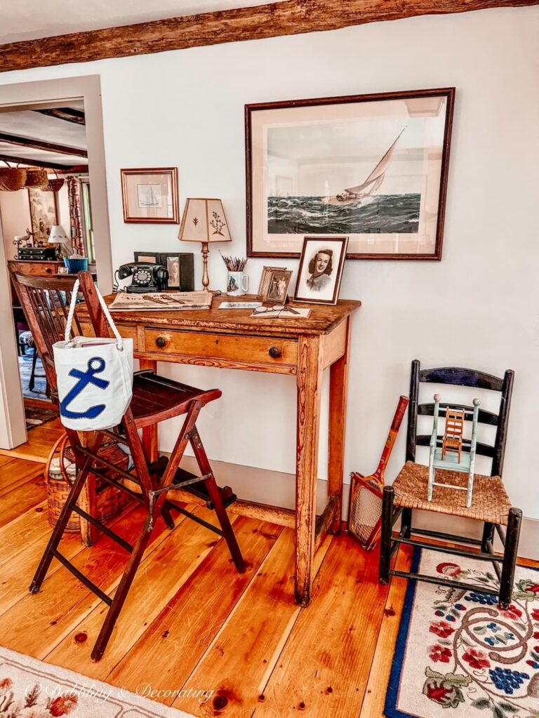 Antique desk displayed in coastal vintage style dining room with antique chairs.