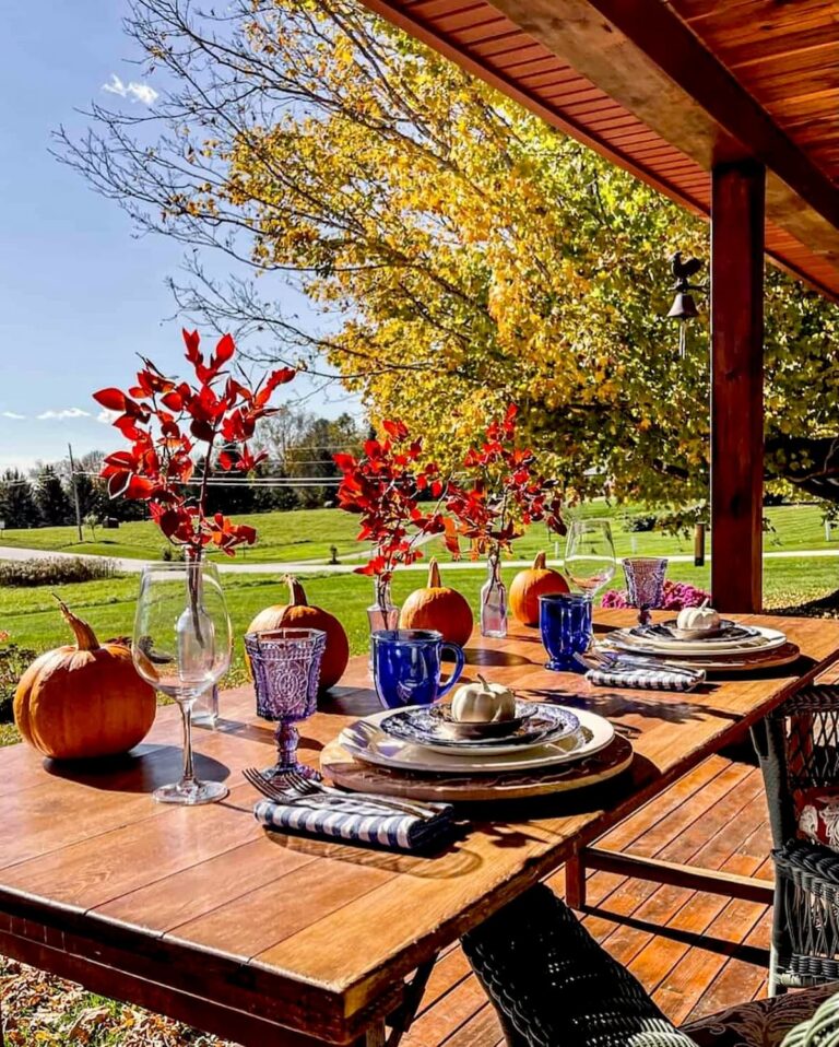 Outdoor front porch table setting with pumpkins and vintage dinnerware with mountain views in the fall.