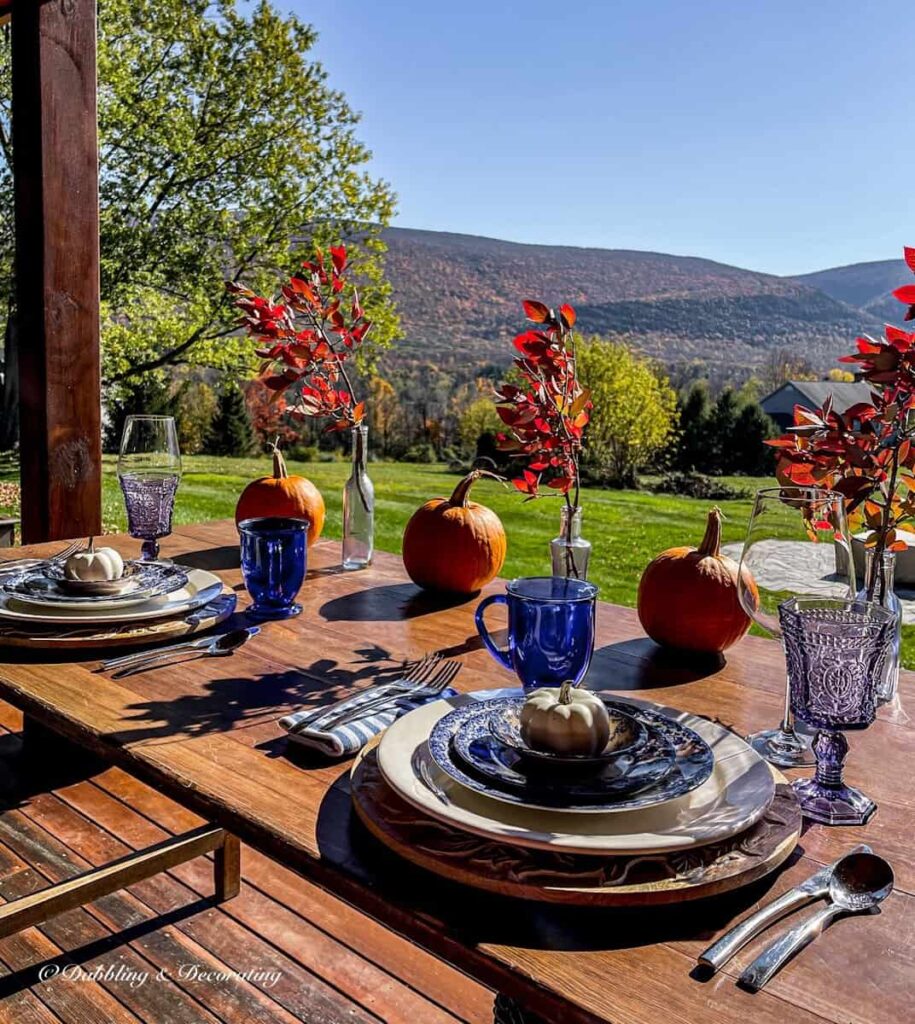 Outdoor front porch table ideas with vintage place settings, pumpkins and forage displays with mountain views.