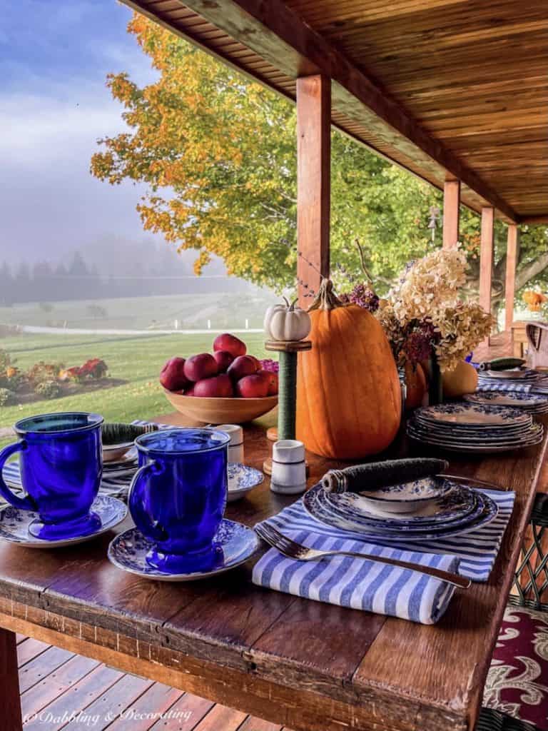 Blue and white fall tablescape on the porch during a misty morning in the mountains.