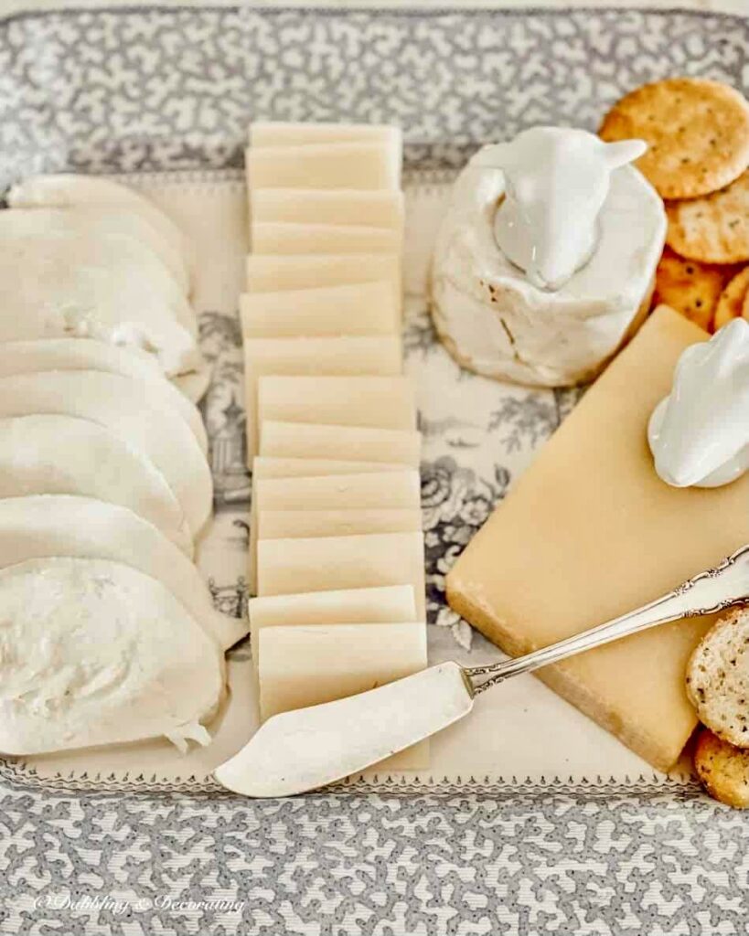 Blue and white vintage platter with fanned Vermont cheeses with cheese holders and cheese knife.